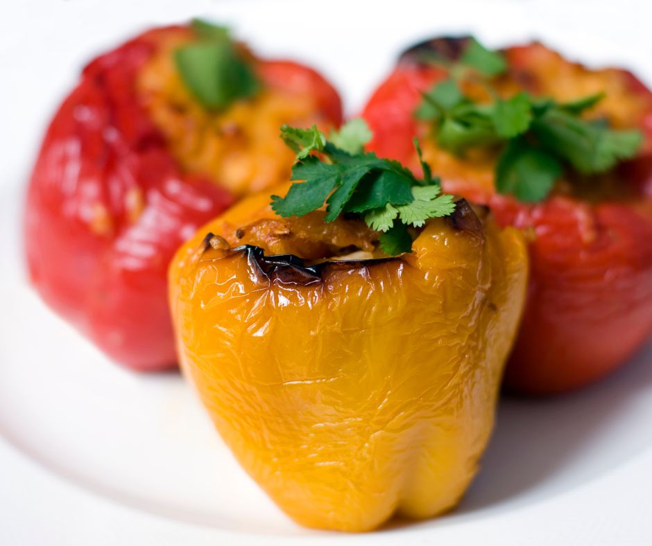 2 poivrons rouges et 1 poivron jaune farcis sur une assiette