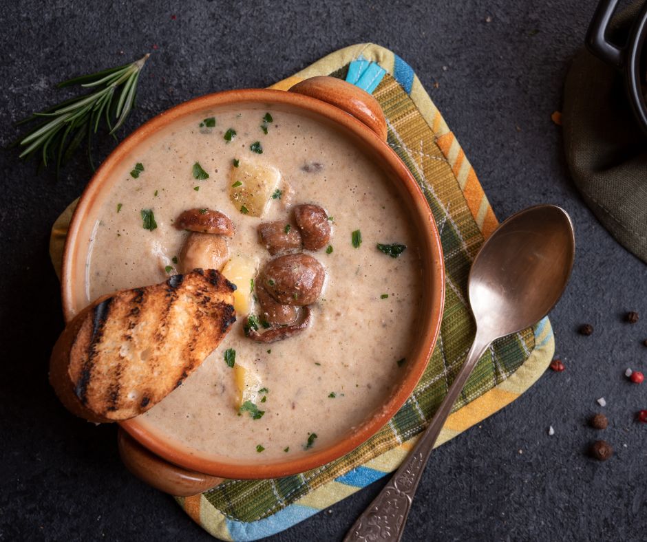 Velouté de cèpes avec quelques morceaux de cèpes dans une assiette avec une tranche de pain grillé