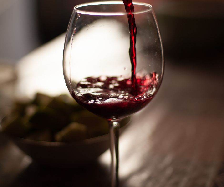 Verre ballon en train d’être rempli de vin rouge de Merlot